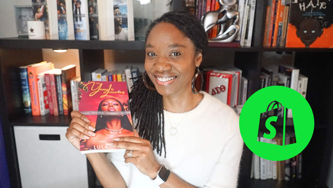 Female Author Lula White holding up a book in front of book case